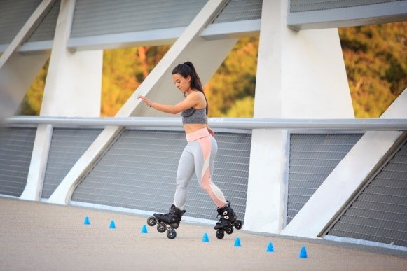 Slalom with inline skates; a girl is slaloming through blue cones